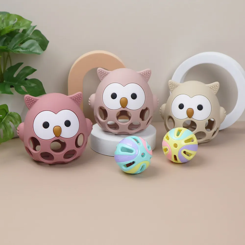 Set of hollow owl silicone teether balls in dusty pink, blush, and cream, with matching rattle balls, food-grade and BPA-free