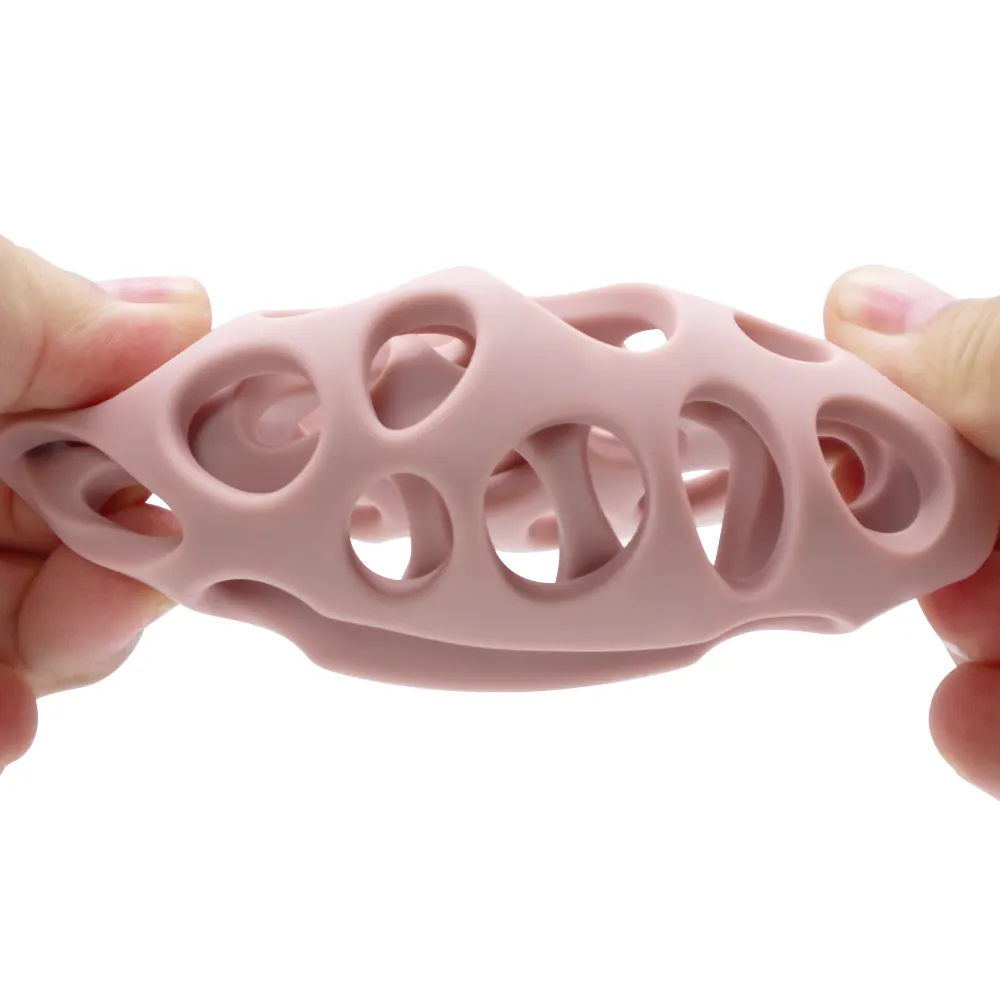 Rose pink hollow round silicone teething ball for babies, flexible and safe chew toy shown being stretched